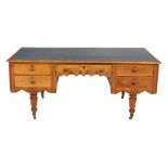 A Victorian Gothic Revival oak desk, circa 1870, the rectangular leather inset top above an