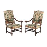 A pair of Louis XIV carved walnut armchairs, late 17th/ early 18th century, each arched rectangular