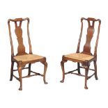 A pair of George II oak chairs, circa 1735, each shaped top rails above a pierced vase splat and