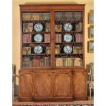 A George III mahogany breakfront bookcase , circa 1800, the moulded cornice above a pair of