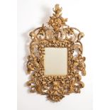 A Continental carved giltwood wall mirror, second half 18th century, the rectangular plate within a