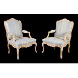 A pair of Louis XV ochre and white painted armchairs , circa 1760, each foliate carved frame