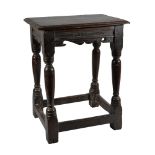 A Charles I oak joint stool, circa 1620, the solid seat with moulded edge above a carved and