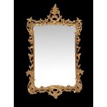 A carved giltwood wall mirror, in George II style , 20th century, the shaped rectangular plate