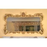 A carved giltwood wall mirror in Louis XV style , 19th century, the shaped oblong plate in a