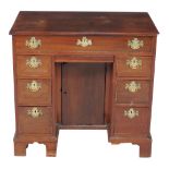 A George III mahogany kneehole desk, circa 1800, with an arrangement of seven drawers and a shallow