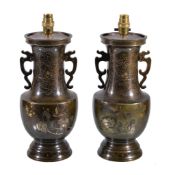 A pair of Japanese inlaid bronze lamps , decorated with butterflies above plantains and stylised