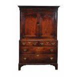 A George III oak cupboard , circa 1780, the panel doors enclosing a shelf, the base with two short