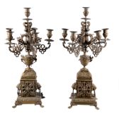 A pair of French gilt metal six light candelabra, circa 1900, the sockets and drip pans on foliate