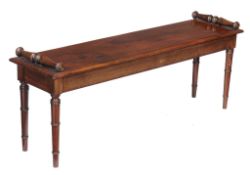 A mahogany hall seat in George IV style , late 19th century, with scrolled ends above the seat and