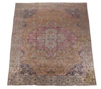 A Tabriz carpet, the dark ochre field decorated profusely with meandering floral foliage, centred