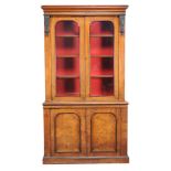 A Victorian walnut and ebonised bookcase-cabinet, circa 1860, the glazed doors enclosing adjustable