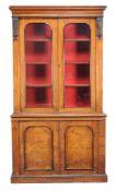 A Victorian walnut and ebonised bookcase-cabinet, circa 1860, the glazed doors enclosing adjustable