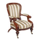 A Victorian mahogany armchair, circa 1870, the 'spoon' shaped back above padded arms with scroll