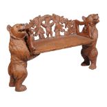 A carved wood hall seat, in the manner of Black Forest examples, 20th century, each end in the form