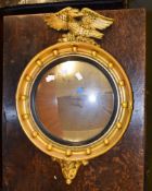 A giltwood mirror in Regency style, the convex plate surmounted by an eagle, 64cm high overall