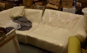 A modern upholstered sofa, in two parts, with a quantity of cushions and covers
