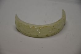 A Chinese white jade hair ornament, of convex shape with pierced floral carving and two holes to