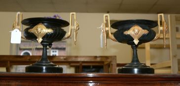 A pair of French patinated and later gold painted twin handled urns, circa 1875, with black marble