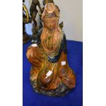 A Chinese pottery figure of Quanyin, seated in flowing robes, glazed in brown and blue, 42cm high