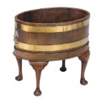 A George III mahogany oval and brassbound wine cooler, circa 1780, now as a jardiniÃ¨re, with