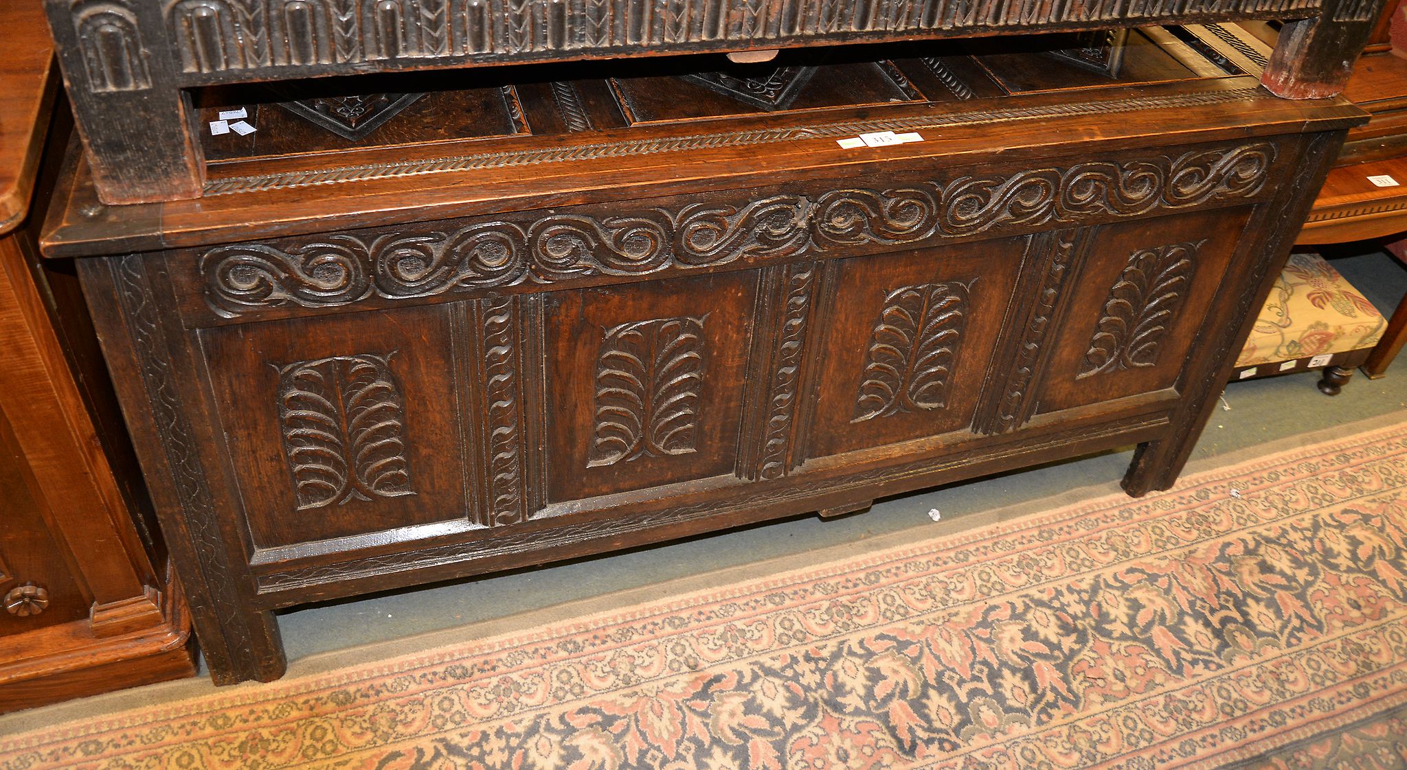 An oak coffer, the three panel lid above an associated coffer base with quadruple panel front, 140cm