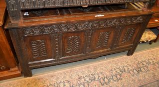 An oak coffer, the three panel lid above an associated coffer base with quadruple panel front, 140cm