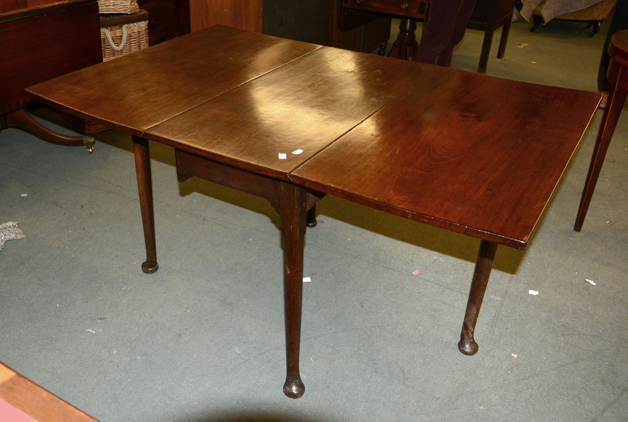 A George II mahogany dropleaf dining table, mid 18th century, on tapering legs and pad feet