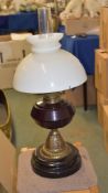 A Victorian oil lamp, with amethyst glass reservoir, 35cm high excluding chimney and shade