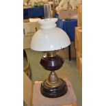 A Victorian oil lamp, with amethyst glass reservoir, 35cm high excluding chimney and shade