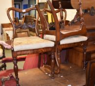 A set of three Victorian walnut side chairs, each with a needlework upholstered drop-in seat