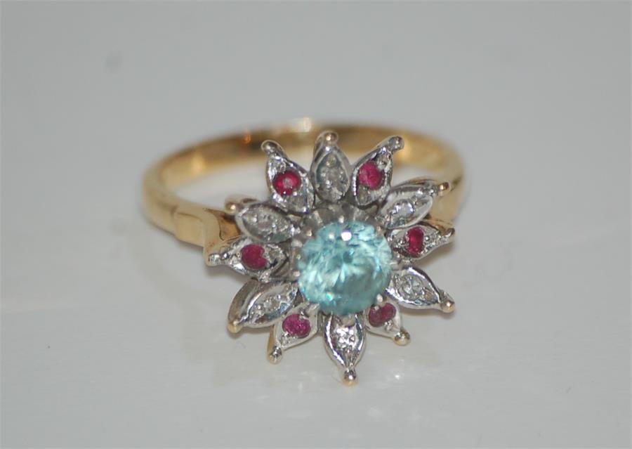 An 18ct Gold Ladies Dress Ring Starburst Set Central Aquamarine Surrounded By Diamonds and Rubies
