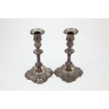 Pair of Geo II S/S Candlesticks with shaped square bases and columns emanating from the base well,