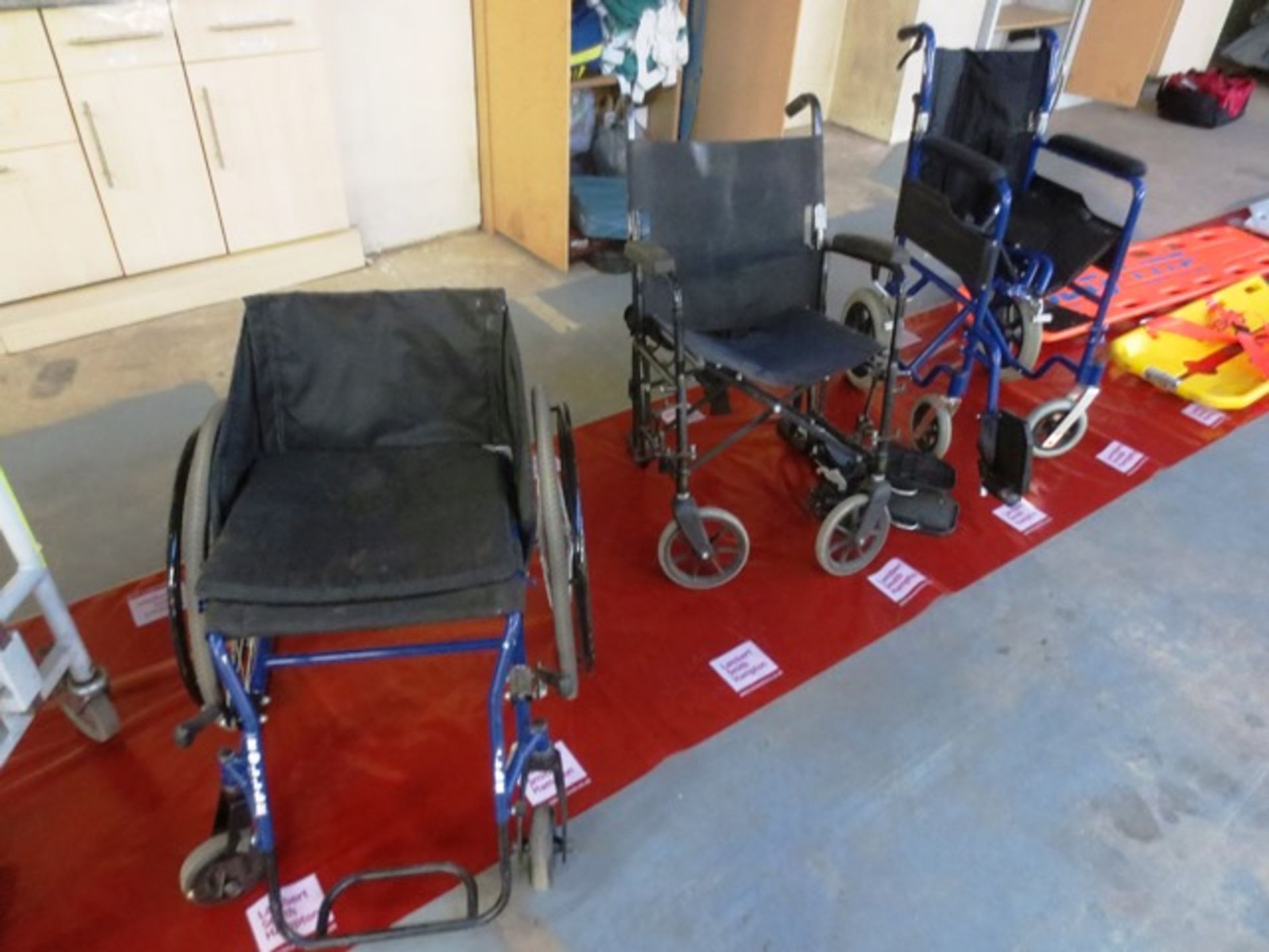 Three out of commission adjustable wheelchairs