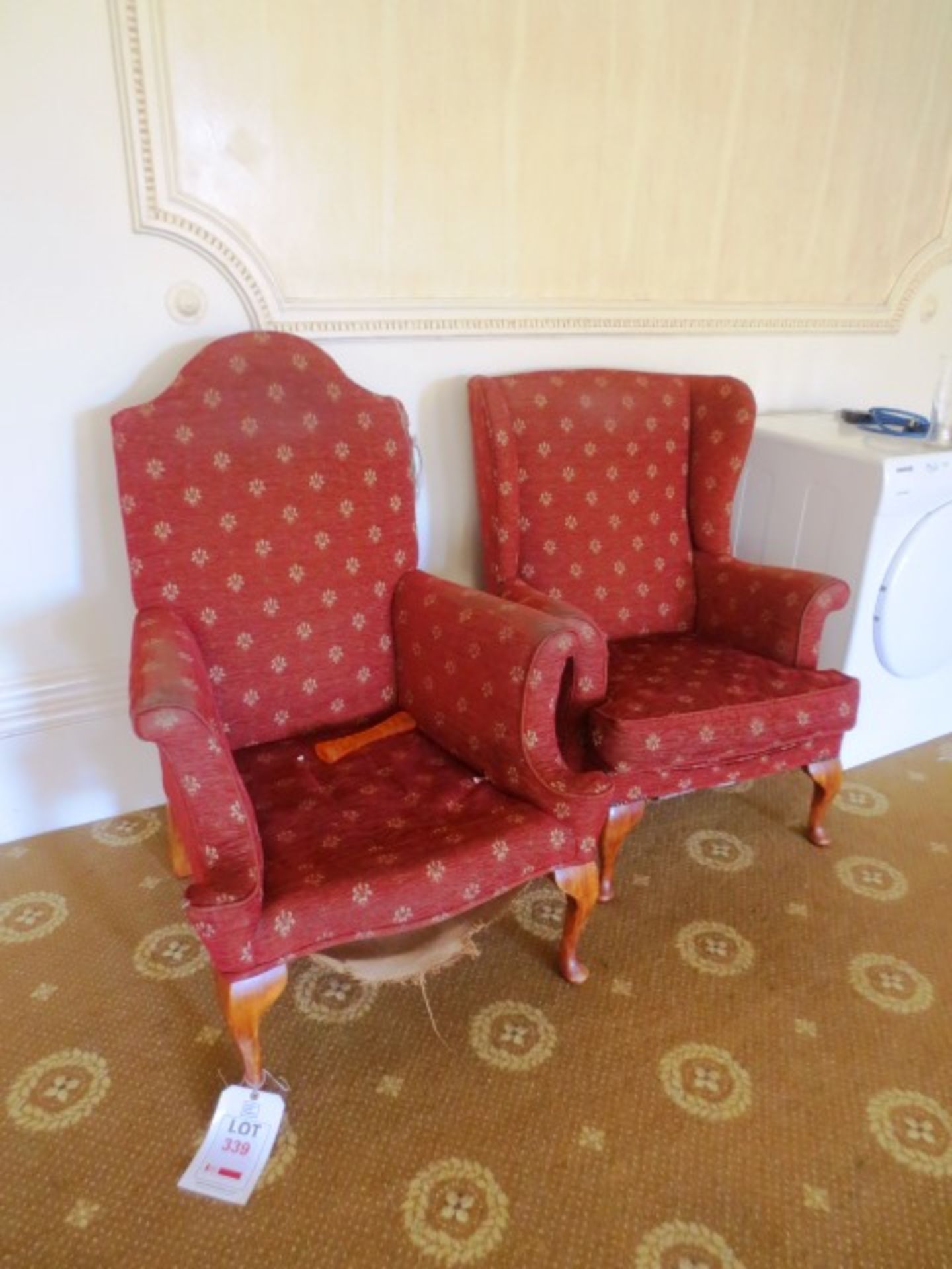 Two red cloth upholstered armchairs (Please note: requires repair)