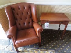 Tan leather arm chair and dark-wood side table