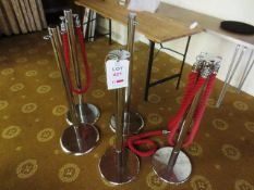 Five chrome-effect uprights with red barrier rope