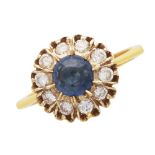 A sapphire and diamond dress ring in 18ct yellow gold, the central round cabochon cut blue