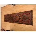 An antique Caucasian runner rug / carpet, red ground with golden border 310x83cm approx.