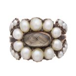 An antique Georgian pearl mourning ring in yellow gold, with an inset panel of woven hair surrounded