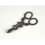 A miniature pair of Antique Silver sugar nips cast with foliate and floral patterns. Length 9cm /