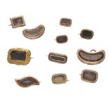 A collection of eleven antique Georgian and later mourning brooches in gold and gilt metal, of