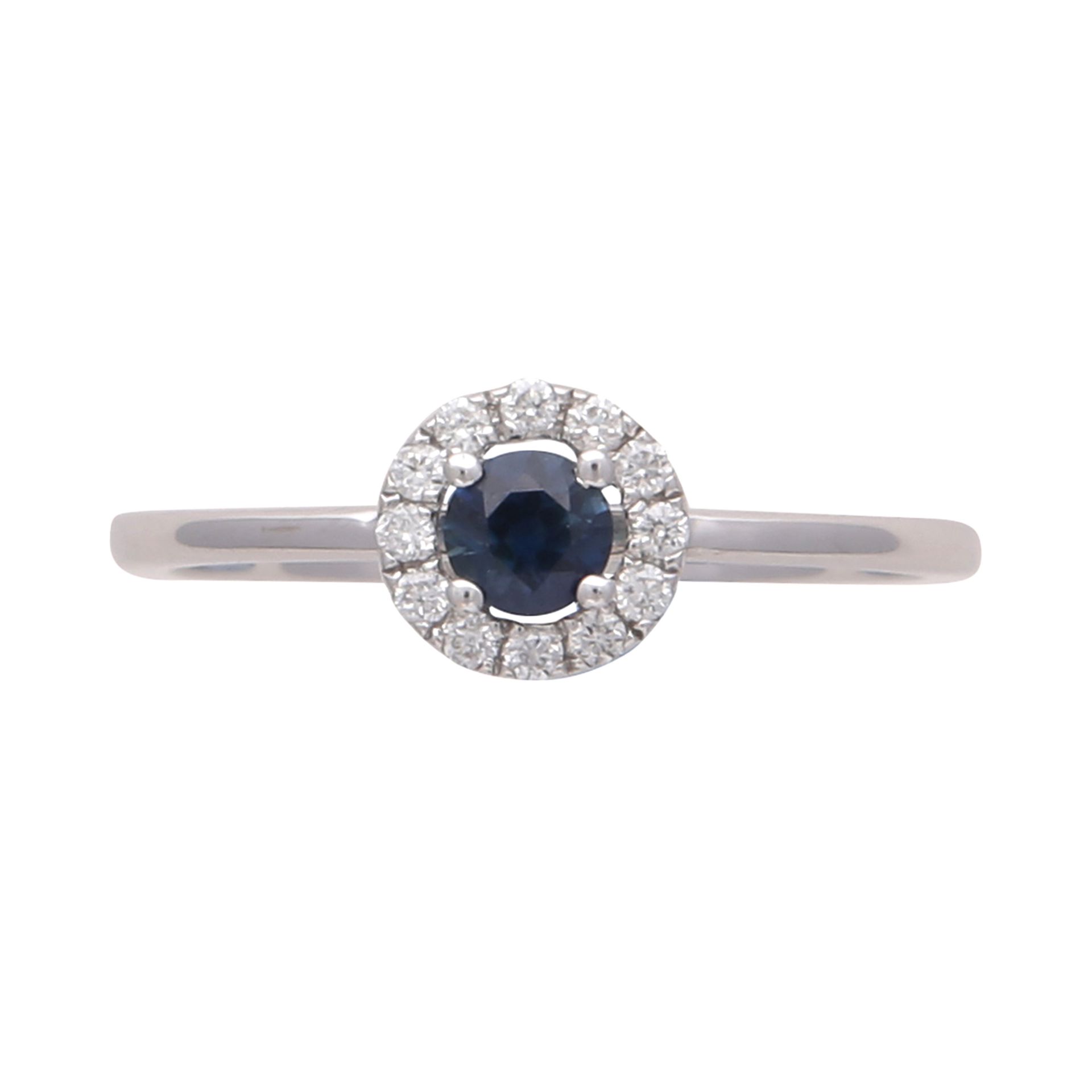 A sapphire and diamond cluster ring in 18ct white gold set with a round cut sapphire surrounded by a