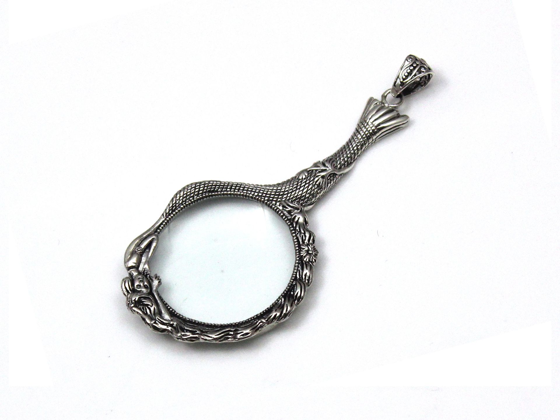 A Sterling Silver mounted magnifying glass pendant designed as a mermaid, her body on one side of