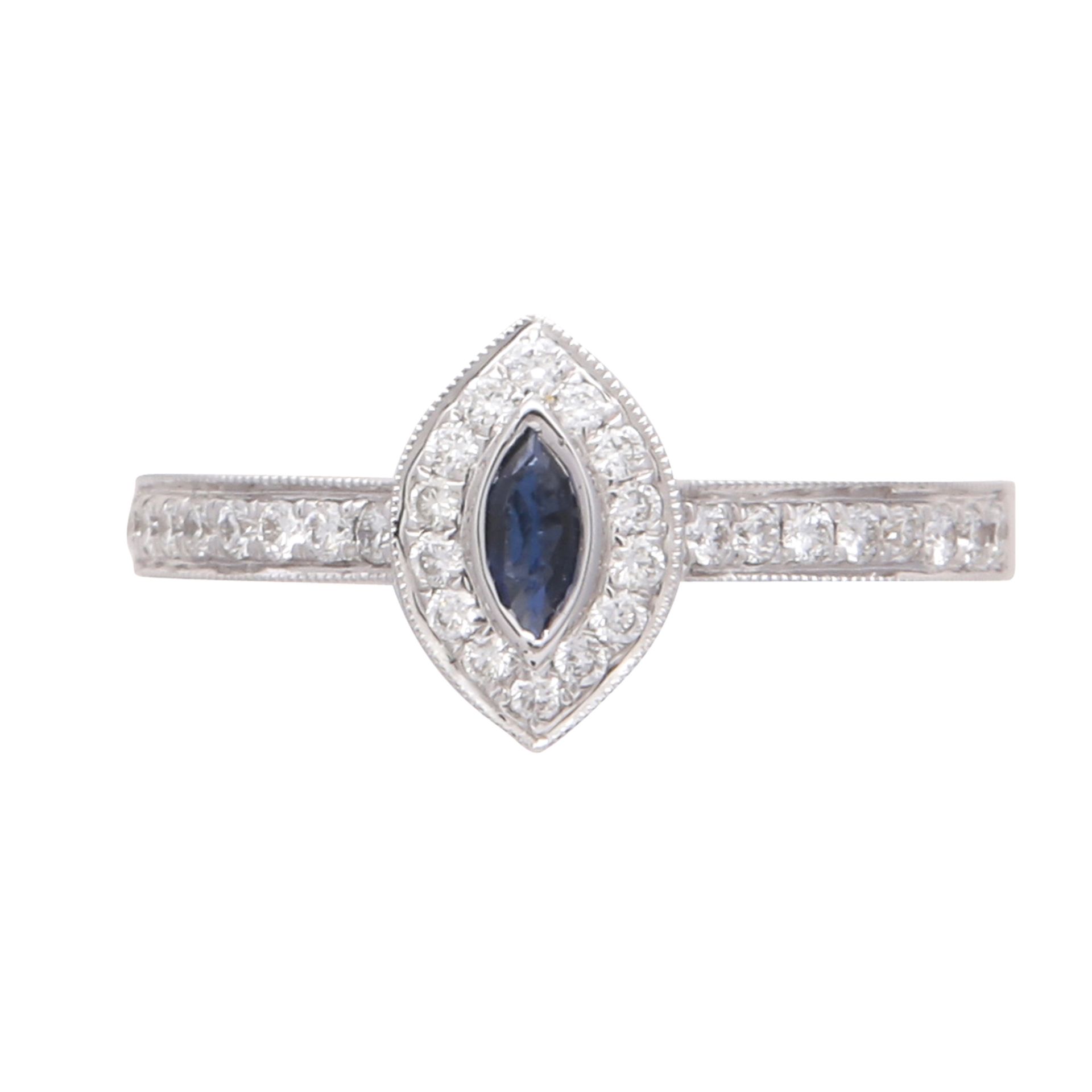 A sapphire and diamond cluster ring in 18ct white gold set with a marquise cut blue sapphire