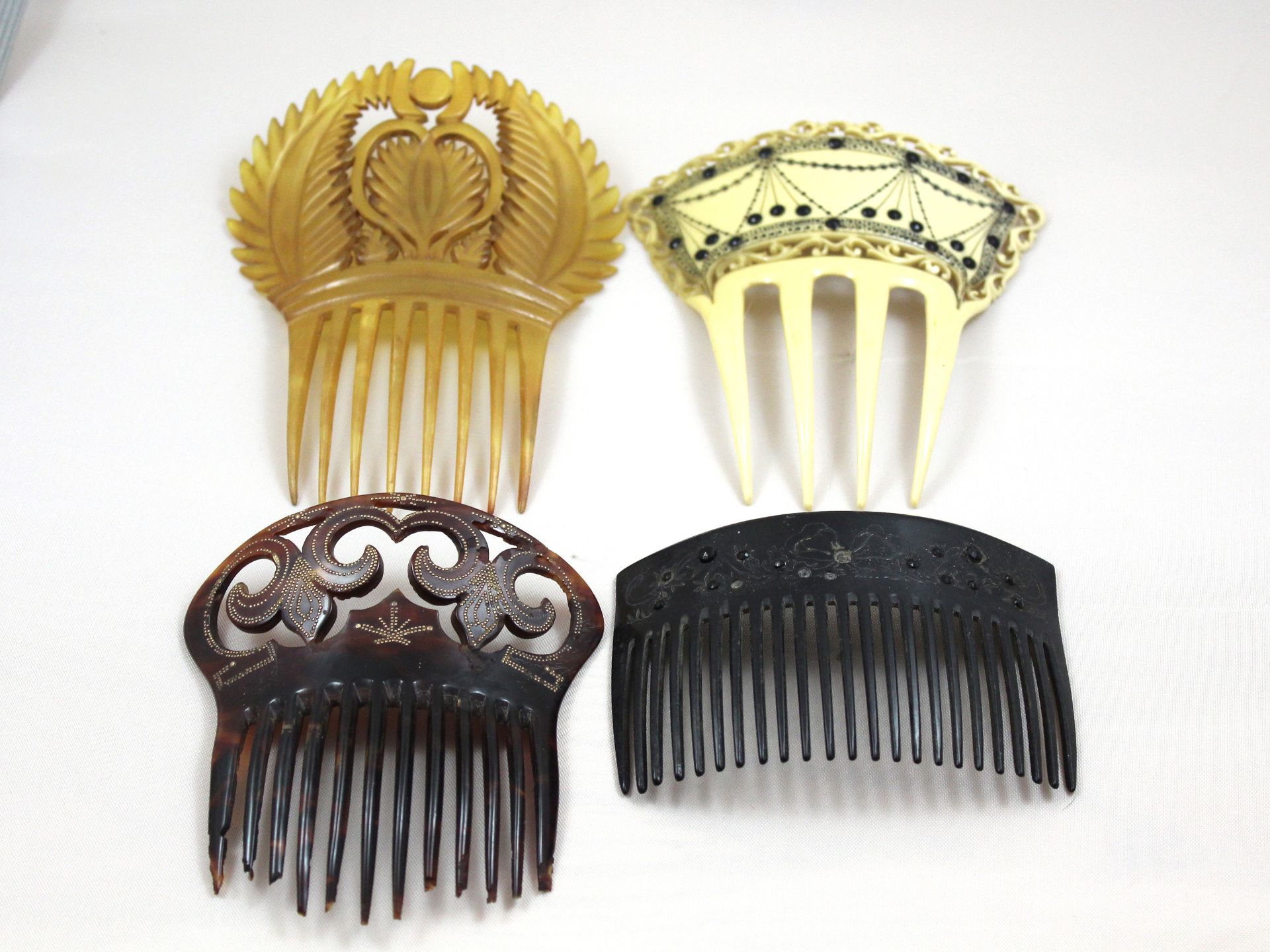 A collection of four antique hair combs to include ivory and tortoiseshell examples, with stud