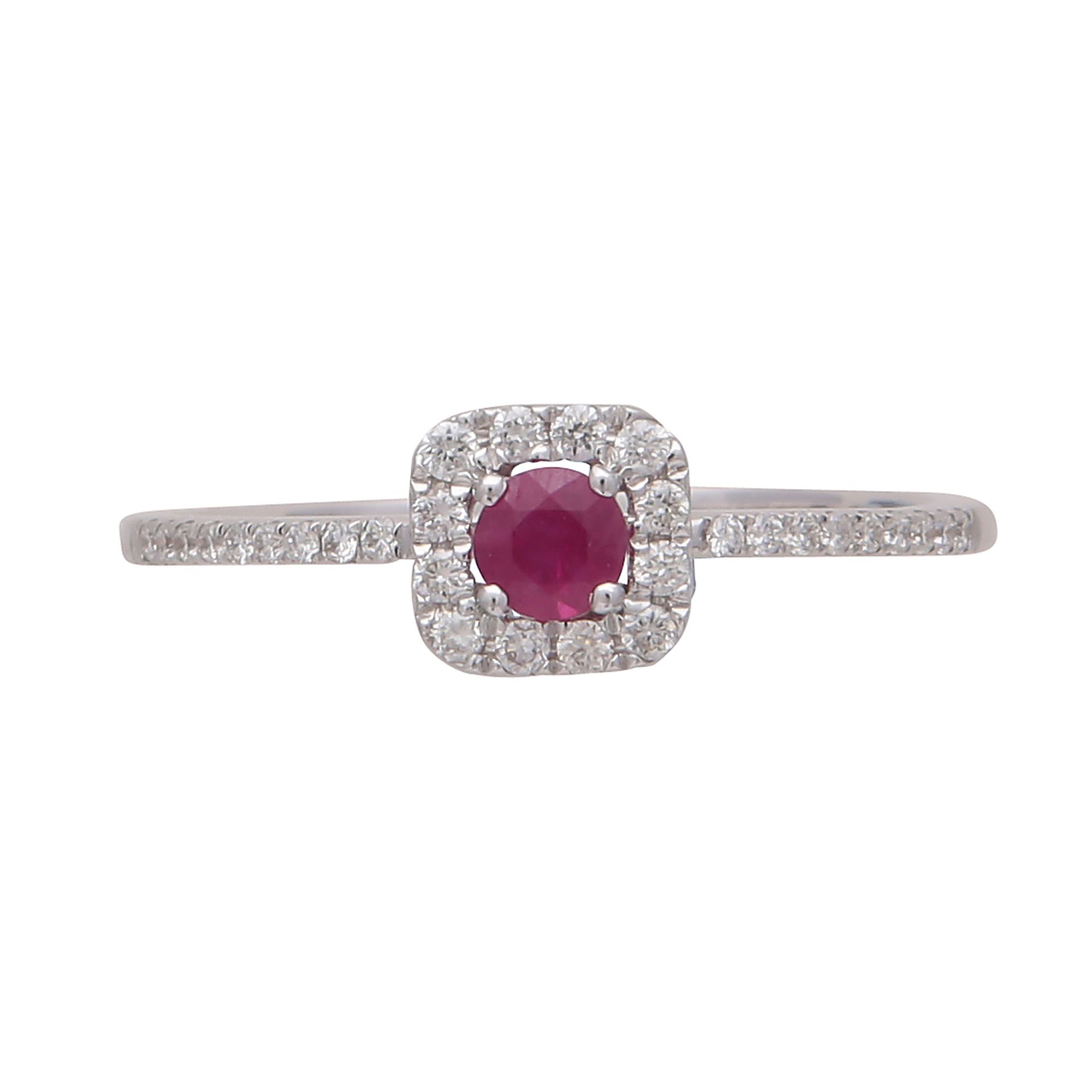 A ruby and diamond cluster ring in 18ct white gold the claw set round cut ruby surrounded by a