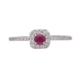 A ruby and diamond cluster ring in 18ct white gold the claw set round cut ruby surrounded by a