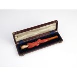 An antique coral and amber cigar / cigarette holder of novelty form, modeled as a fish carved from