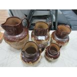 Graduated set of 4 Doulton Harvest jugs + similar larger jug